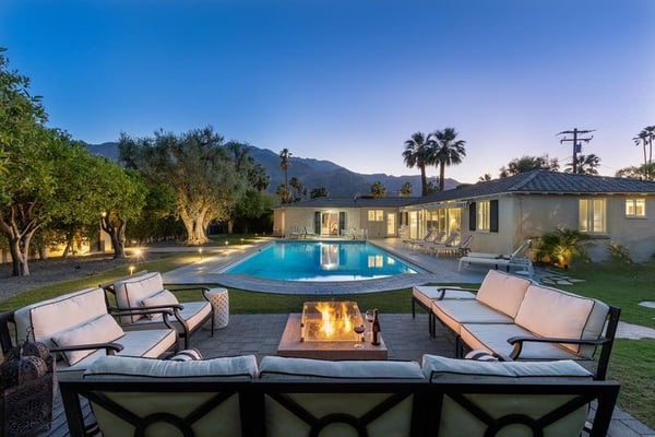 Vacation rental patio with pool and fire pit at dusk